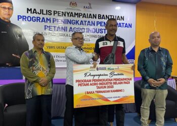 SYED Ali Dustur Syed Mohd. Zain (dua dari kiri) menyampaikan replika penerimaan bantuan ternakan di Pejabat KADA Pasir Puteh, Kelantan, hari ini. UTUSAN/TOREK SULONG