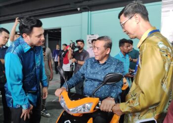 AMINUDDIN Harun (tengah) mencuba sebuah motosikal elektrik selepas merasmikan pembukaan Careplus Mall di Seremban 2, Seremban hari ini.