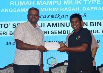 J. ARUL Kumar (kiri) bersama salah seorang pemohon yang terpilih bagi memiliki rumah bagi projek Taman Angsamas 2 pada Majlis Pengundian Rumah Mampu Milik Type A- RM 80,000, Taman Angsamas 2, Seremban semalam.