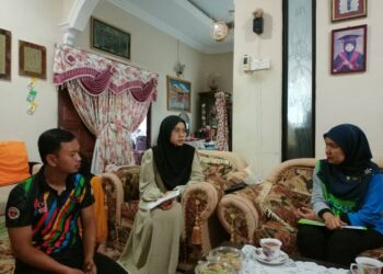 NORA Yaacob (kanan) bertanya khabar Nur Hasifah (tengah) sebelum menyampaikan baucer pencen penakat di rumahnya Kampung Tapang, Panji, Kota Bharu, Kelantan-UTUSAN/ROHANA MOHD.NAWI