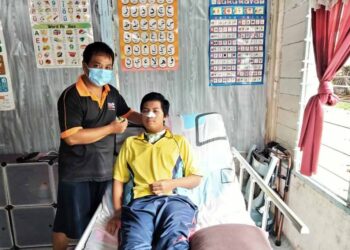 SUHAILI Ahmad ( kiri ) bersama  Muhammad Khairul Ikhwan setelah terlibat dengan kemalangan jalan raya di rumahnya di Kampung Parit Wer, Telok Kerang, di Pontian. – UTUSAN/MUHAMMAD ZIKRI