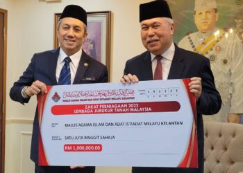 TENGKU Mohamad Rizam Tengku Abdul Aziz (kanan) menerima bayaran zakat dari Lembaga Jurukur Tanah Malaysia pada Majlis Pembayaran Zakat Kepada MAIK di Kompleks Balai Islam Lundang, Kota Bharu, Kelantan hari ini. UTUSAN/MUSTAQIM MOHAMED.