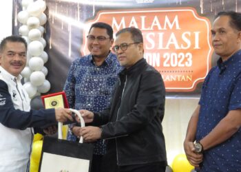AZMAN Ismail (dua dari kanan) menyampaikan sijil penghargaan kepada penerima sempena Program Malam Apresiasi Gerakan Pengguna Daerah (GPD) Gua Musang di Taman Etnobotani di Gua Musang, Kelantan malam tadi.-UTUSAN/AIMUNI TUAN LAH