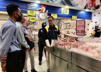 AZMAN Ismail (kanan) melihat daging sejuk beku di bawah barangan kawalan sempena SHMMP Krismas 2023 di sebuah pasaraya di Kubang Kerian, Kota Bharu, Kelantan hari ini.- UTUSAN/ ROSLIZA MOHAMED.