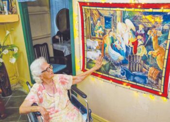 EVELYN Lowe menunjukkan gambar yang dibeli di Australia membawa unsur-unsur perayaan Krismas 
di rumahnya di Perkampungan Portugis, Ujong Pasir, Melaka. – UTUSAN/SYAFEEQ AHMAD