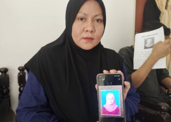 NORHIDAWATY Mohd. Yusof menunjukkan gambar Nurul Syakila yang hilang ketika ditemui pemberita di Kampung Sungai Layang, Rembau hari ini.-UTUSAN/NOR AINNA HAMZAH.