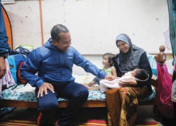 AHMAD Samsuri Mokhtar (kiri) bertanyakan khabar kepada mangsa banjir semasa melawat Pusat Pemindahan Sementara (PPS) Sekolah Kebangsaan Chendering, Kuala Terengganu, hujung Mac lalu. -UTUSAN/PUQTRA HAIRRY