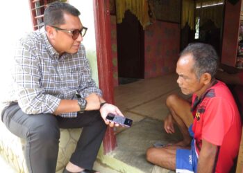 MOHD. Syahbuddin Hashim menyantuni penduduk Orang Asli yang masih gagal menebus eMadani sebanyak RM100 di Kampung Char, Pos Hendrop, Gua Musang, Kelantan. – UTUSAN/AIMUNI TUAN LAH