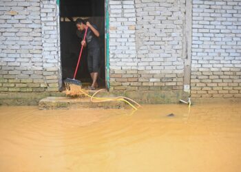 SEORANG penduduk membersihkan rumahnya yang dipenuhi lumpur dalam kejadian banjir di Kampung Tok Kah, Dungun, semalam. - UTUSAN/PUQTRA HAIRRY ROSLI