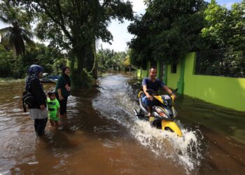 PENDUDUK di Kampung Jejulok, Tumpat, Kelantan mula meredah sejak semalam.-UTUSAN/KAMARUL BISMI KAMARUZAMAN