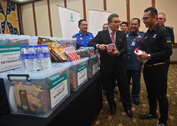 TENGKU Farok Hussin Tengku Abd. Jalil (depan. dua kiri) melihat sebahagian daripada kit bantuan kepada mangsa banjir yang disediakan Yayasan Petronas pada majlis penyampaian sumbangan pakej prihatin Yayasan Petronas di Kuala Terengganu, semalam. - UTUSAN/PUQTRA HAIRRY ROSLI