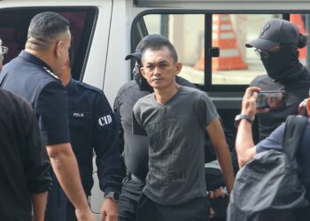 AFENDI Muhammad Agus dibawa anggota polis ke Mahkamah Majistret Kuala Lumpur bagi menghadapi pertuduhan membunuh ibu bapanya. UTUSAN/SHIDDIEQIIN ZON