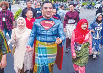 MOHD. NOOR HELMY Abd. Halem bersama orang ramai melakukan larian dengan memakai baju Superman. Suasana yang cukup meriah dihadiri seramai 2000 peserta pada Program Larian Budaya Duyong Kita di Perkampungan Hang Tuah, Duyong, Melaka. – UTUSAN/SYAFEEQ AHMAD
