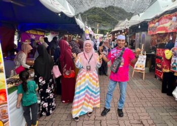 HASNIFAZLINA Hassan (kiri) bergambar di hadapan salah sebuah gerai Perlis Mega Food Festival yang dianjurkan di Dataran Datuk Sheikh Ahmad, Kangar, Perlis, selama tiga hari sehingga Ahad. -UTUSAN/ASYRAF MUHAMMAD
