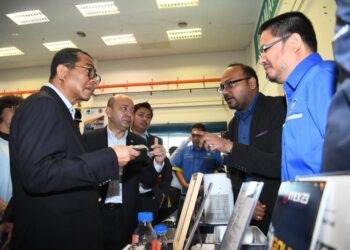 MOHAMED Khaled Nordin (kiri) bertanyakan sesuatu kepada peserta pameran selepas merasmikan Pusat TVET Unimap di Arau, Perlis hari ini. -UTUSAN/IZLIZAN OTHMAN