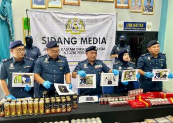 ISMAIL Hashim (tiga dari kiri) menunjukkan gambar ketulan mampat dipercayai ganja yang ditemukan dalam bagasi suspek menerusi serbuan di Kompleks ICQS Wang Kelian, Padang Besar, Perlis dalam sidang akhbar di Padang Besar, Perlis.- UTUSAN/ASYRAF MUHAMMAD