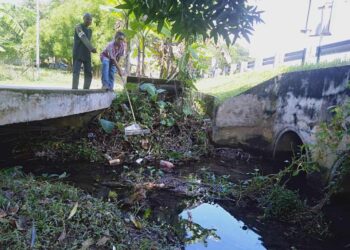 MOKHTAR Dahari (kiri) bersama Husairi Hussain menunjukkan longkang besar dipenuhi tanah dan sampah sarap di Kampung Bakar Kapor, Sungai Petani, Kedah. -UTUSAN/OTHMAN YAHAYA