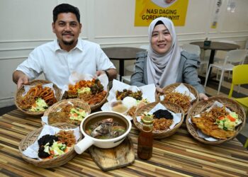 MARIAM @ Sharifah Mariam Sh Along bersama suaminya, Tengku Iskandar Tengku Salim menunjukkan menu hidangan yang disediakan di restoran Kunyek Kunyek, di Kuala Nerus, Terengganu. - MINGGUAN/KAMALIZA KAMARUDDIN