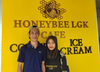 Pasangan suami isteri, Muhamad Syakir Idris, dan Nur Fatihah Arun di hadapan kedai menjual aiskrim dan kopi, Honeybee LGK Cafe di Jalan Ulu Melaka, Ayer Hangat, Langkawi.