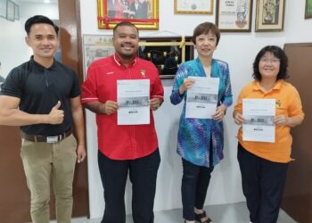 NICOLE Tan Lee Koon (dua dari kanan) menunjukkan bahan cetak kempen pendaftaran sistem pangkalan data utama (PADU) di Pusat Khidmat DUN Bukit Kepayang di Seremban hari ini.-UTUSAN/NAZARUDIN SHAHARI.