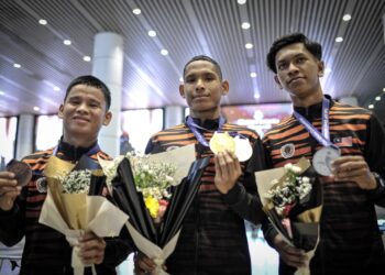 Zaiman Megat Abu (tengah) Hazrul Shah Hamri (kanan) dan  Azlan Kunte menunjukkan pingat yang dimenangi di KLIA, Sepang, semalam.- UTUSAN/FAIZ ALIF ZUBIR