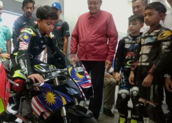 AHMAD Samsuri Mokhtar (tengah) melihat aksi Qabil Irfan Azlan mengendalikan  jenteranya di  Litar Permotoran Terengganu, Kuala Nerus, petang tadi. - UTUSAN/TENGKU DANISH BAHRI TENGKU YUSOFF