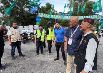 PETUGAS Pas mengambil kesempatan bergambar dengan calon BN, Raja Mohamed Affandi Raja Mohamed Noor (dua kanan) di  Unit Daerah Mengundi Rantau Petronas berhampiran Sekolah Kebangsaan Kampung Baru Kerteh, Kemaman, hari ini. - UTUSAN/NIK NUR  IZZATUL HAZWANI NIK ADNAN