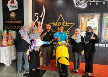 MOHD. Huzairil Nizam Ibrahim (tiga, kanan) menunjukkan hadiah utama, skuter Banelli Panarea 125 untuk pengunjung bertuah ke 150,000 di PSKT di Kampung Laut, Kuala Terengganu, hari ini. - UTUSAN/KAMALIZA KAMARUDDIN