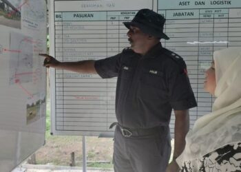 SHARIFAH Azizah Syed Zain mendengar penerangan daripada Ketua Polis Balai Kluang, Inspektor A. Jagadhesan ketika hadir membuat lawatan di Pusat Kawalan Tempat Kejadian di Kampung Palembang, Kluang, hari ini.