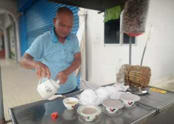 LAI Chee Leong menyediakan air tebu rebus yang dijualnya ketika ditemui di Jalan Dr. Krishnan, Seremban.-UTUSAN/NUR SHARIEZA ISMAIL