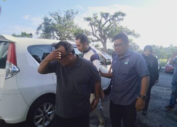 SUCHART Ee @ Quah (depan) dan Mohammad Nahur Azad Ibrahim (tengah) dikawal anggota polis semasa dibawa untuk proses pendakwaan di Mahkamah Sesyen Sungai Petani.