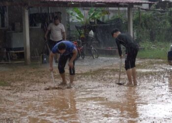 PENDUDUK membersihkan lumpur selepas banjir mulai surut di Kampung Tebing Tembah, Paka, Dungun, semalam. - UTUSAN/NIK NUR IZZATUL HAZWANI NIK ADNAN