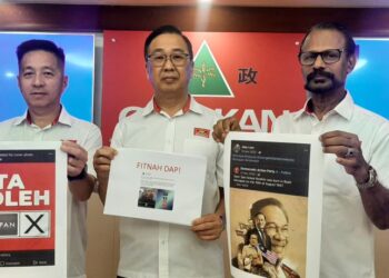 DOMINIC Lau (tengah) memegang poster berkaitan politik.