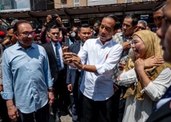 JOKO Widodo berswafoto bersama pengunjung di Pasar Jalan Raja Alang, Chow Kit, Kuala Lumpur sambil diperhatikan Anwar Ibrahim (kiri). GAMBAR SADIQ ASYRAF/Pejabat Perdana Menteri