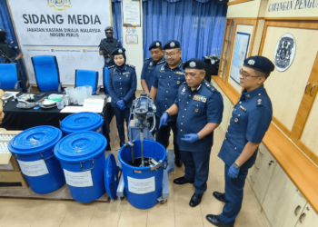 ISMAIL HASHIM (dua dari kanan) menunjukkan mesin pemprosesan ubat batuk yang dirampas dalam sidang akhbar di pejabat JKDM Kuala Perlis hari ini. - UTUSAN/SYED AZLAN SAYID HIZAR