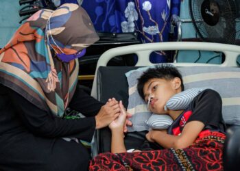 SUHAILI Zainal memegang tangan Muhammad Aqeef Irmi Shahrizan ketika ditemui di Taman Bukit Rambai, Melaka. - UTUSAN/SYAFEEQ AHMAD