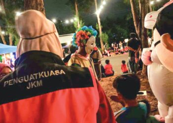 PENGUAT kuasa JKM memeriksa pemakai maskot yang menjalankan kegiatan di sekitar Banda Hilir, Melaka. 
– UTUSAN/SYAFEEQ AHMAD