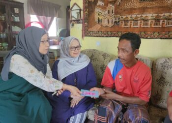 Zuraini (kiri) menyerahkan ) menghulurkan sumbangan kepada pesakit kanser
