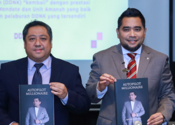 Datuk Dr Nazri Khan atau DDNK (kanan) bersama Naib Presiden Kanan Pelaburan dan Pengurus Dana Bebas IPAM, Heddy Humaizi (kiri) menunjukkan buku Autopilot Millionaire pada sidang media di Kuala Lumpur baru-baru ini.