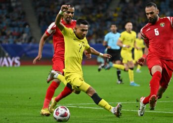 FAISAL Halim cuba melepasi dua pertahanan Jordan dalam aksi Piala Asia 2023 di Doha, semalam. - AFP