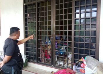 MOHD. Asyraf Bakri menunjukkan tempat mayat guru wanita yang ditemukan mati  dalam rumah sewanya  di Kampung Pengadang Baru, Kuala Terengganu, hari ini. - UTUSAN/PUQTRA HAIRRY ROSLI