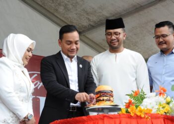 ONN HAFIZ GHAZI memotong kek berbentuk burger sambil diperhatikan dari kiri oleh Pengarah Eksekutif Lazy Monday, Datuk Siti Aminah Ahmad, pemilik Lazy Monday  Datuk Seri Syamsul Omar dan Mohd. Hairi Mad Shah pada Majlis Perasmian Restoran Lazy Monday di Tebing Bandar Dato' Onn, Johor Bahru.