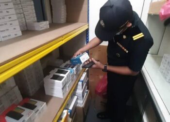 ANGGOTA KPDN memeriksa sebuah premis perniagaan yang dipercayai menjual produk telefon dan aksesori yang mengguna pakai cap dagangan berdaftar secara salah, di George Town, Pulau Pinang, semalam.