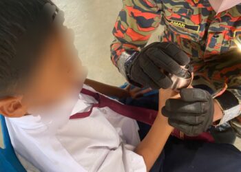ANGGOTA bomba mengeluarkan jari tangan seorang murid yang tersangkut pada tombol pintu di Klinik Kesihatan Sri Langkap, Setiu, hari ini.