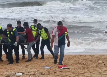 ANGGOTA polis mengusung mayat dipercayai seorang lelaki yang ditemukan tanpa kepala di Pantai Rantau Abang, petang tadi. - UTUSAN/NIK NUR IZZATUL HAZWANI NIK ADNAN