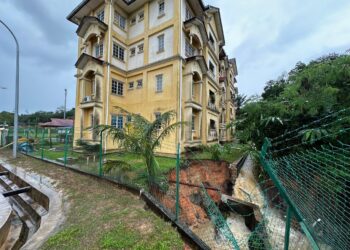 SEBAHAGIAN mendapan tanah yang berlaku berhampiran bangunan kuarters SK Bandar 2 Paloh Hinai di Pekan, Pahang. - FOTO IHSAN IPD PEKAN