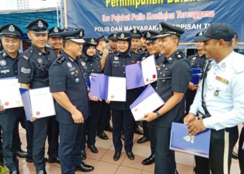 MAZLI Mazlan (tiga dari kiri) memperkata sesuatu kepada anggota polis yang menerima sijil penghargaan pada Perhimpunan Bulanan IPK Terengganu, hari ini. - UTUSAN/TENGKU DANISH BAHRI TENGKU YUSOFF