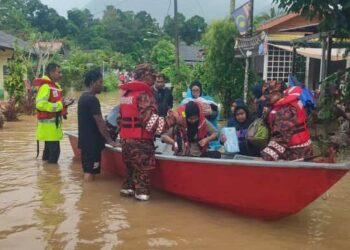 ANGGOTA bomba membantu memindahkan mangsa terjejas banjir di Bukit Ibam di Rompin, Pahang.