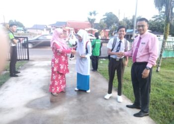 NORHAFIZAH Nasiron (kiri) dan Anuar Salleh menyambut kehadiran calon-calon peperiksaan SPM 2023 yang menduduki Ujian Bertutur Bahasa Melayu di SMK Dato' Penggawa Barat, Pontian.