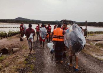 ANGGOTA bomba menyelamatkan pekerja ladang yang terperangkap akibat banjir di kawasan Sungai Ulu Pengeli, Kota Tinggi.